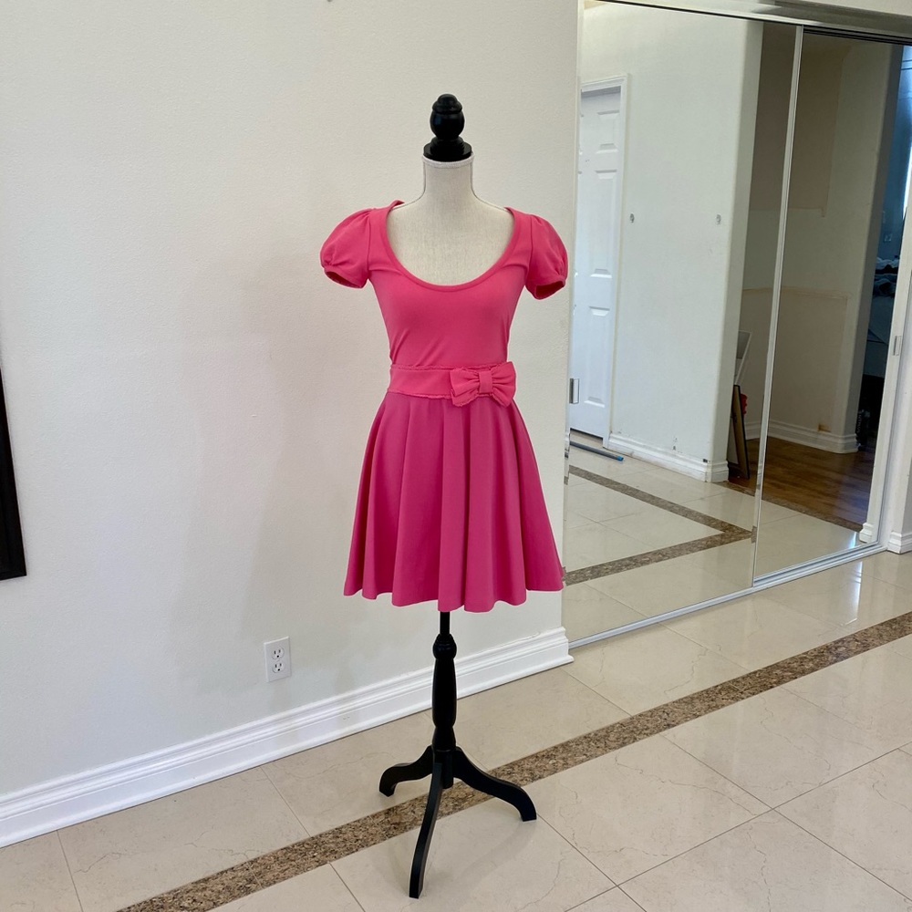 Pink mini skater dress with a bow.